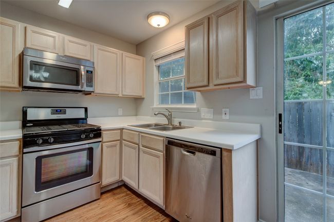 Kitchen featuring stainless steel appliances, a sink, light countertops, and light wood finished floors | Image 17