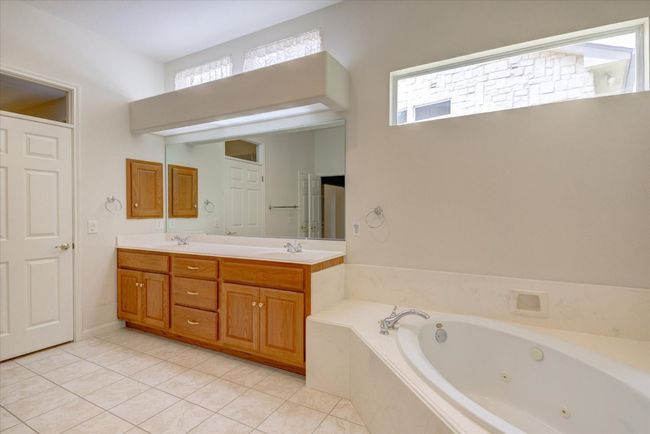 Primary bath with double vanity, a whirlpool tub, and tile patterned flooring | Image 17