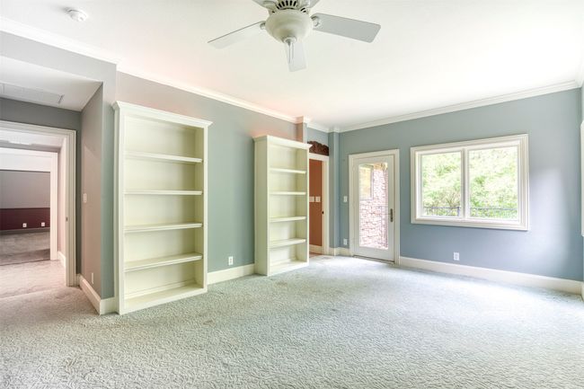 Upstairs bedroom with built-ins and balcony. | Image 20