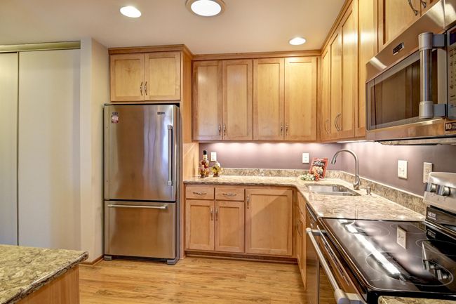 Updated kitchen features stainless steel appliances, laminate flooring | Image 10
