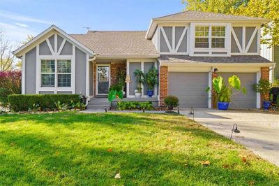 Tudor-style house with a garage and a front lawn | Image 2