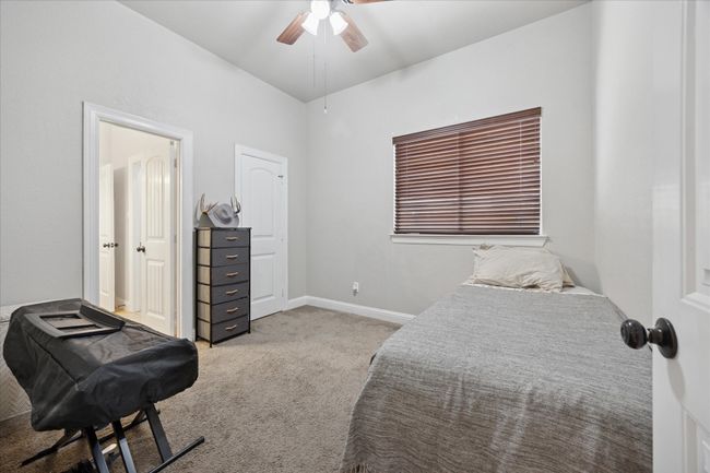 Carpeted bedroom with a ceiling fan and baseboards | Image 16