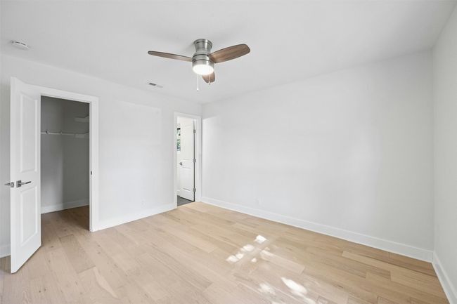 Unfurnished bedroom featuring a spacious closet, light wood finished floors, a closet, and ceiling fan | Image 22