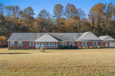 Ranch-style house with a front yard and covered porch | Image 1