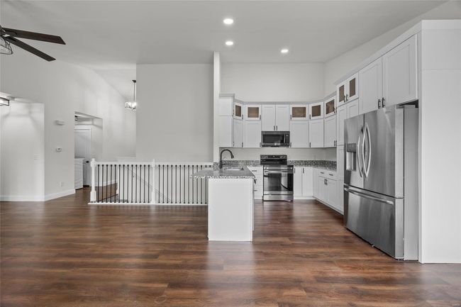 Kitchen with ceiling fan, appliances with stainless steel finishes, light stone countertops, a peninsula, and recessed lighting | Image 25