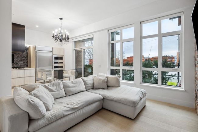 Living room with baseboards, a notable chandelier, and light wood-style flooring | Image 6