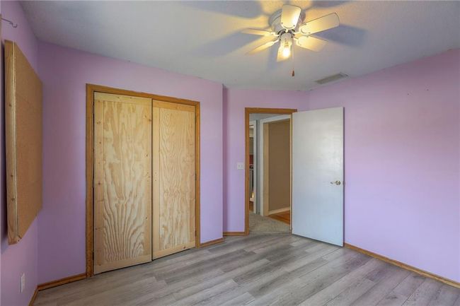 Unfurnished bedroom featuring a closet, a ceiling fan, baseboards, visible vents, and light wood-style floors | Image 13