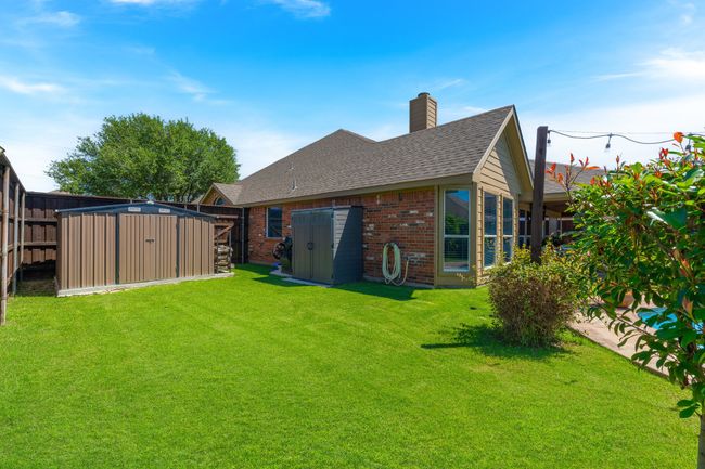 Back of property featuring brick siding, a chimney, and a shingled roof | Image 37