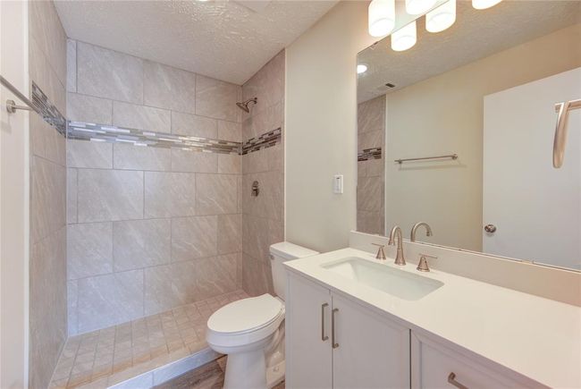 Primary bathroom has all new shower with decorativo glass mosaic inserts and a new toilet. All bathrooms have new vanity cabinets with counters, new sinks and faucets, new mirrors and light fixtures and new towel bars and cabinet hardware! | Image 17