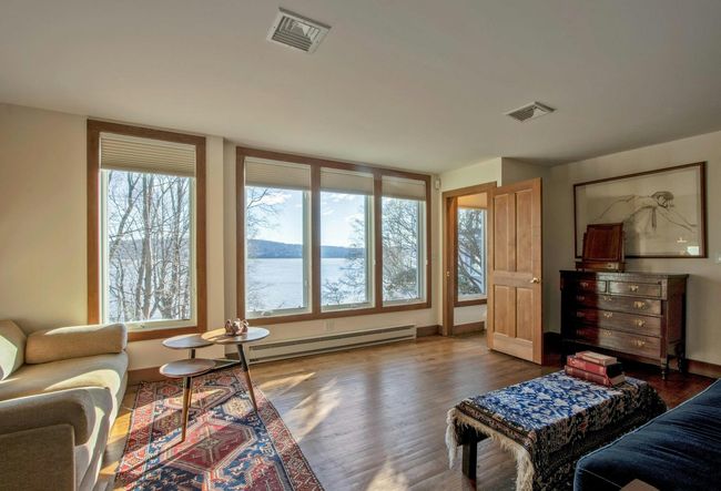 Living room with baseboard heating, dark hardwood / wood-style floors, and a water view | Image 25