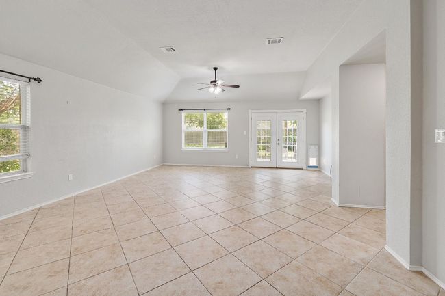 Unfurnished room featuring ceiling fan, light tile patterned floors, vaulted ceiling, and french doors | Image 4