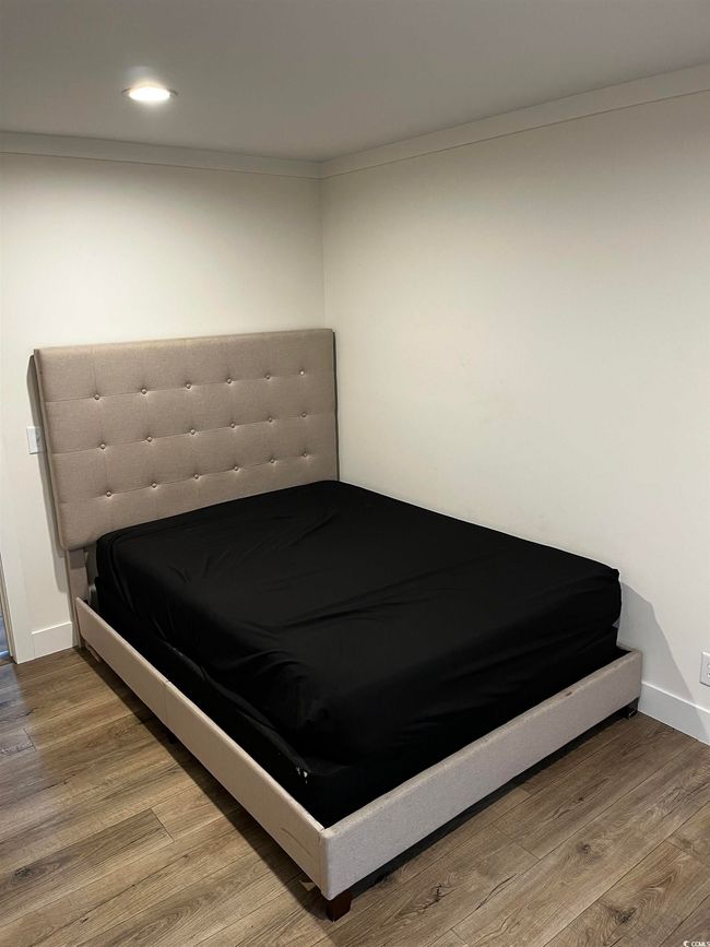 Bedroom with wood finished floors and recessed lighting | Image 12