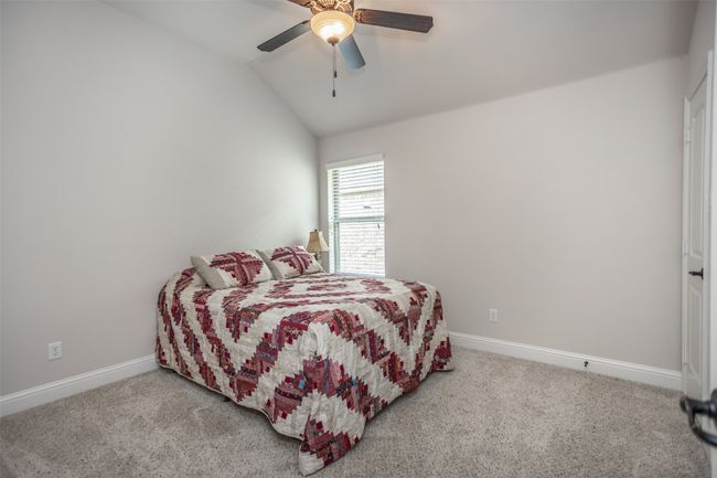 Carpeted bedroom with lofted ceiling and ceiling fan | Image 33