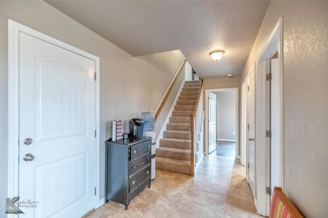 Entryway with stairs, light tile patterned floors, and a textured ceiling | Image 22