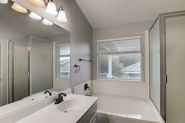 Bathroom featuring a bath, vanity, and a shower with door | Image 22