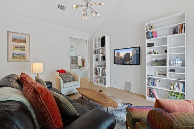 Living room with a chandelier, light wood-style floors, and vaulted ceiling | Image 8
