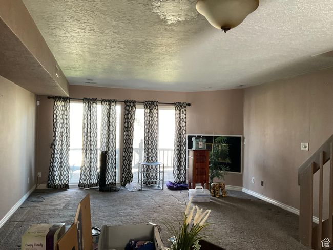 Unfurnished living room featuring baseboards and a textured ceiling | Image 12