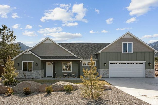 Craftsman-style house with board and batten siding, a porch, stone siding, and concrete driveway | Image 41