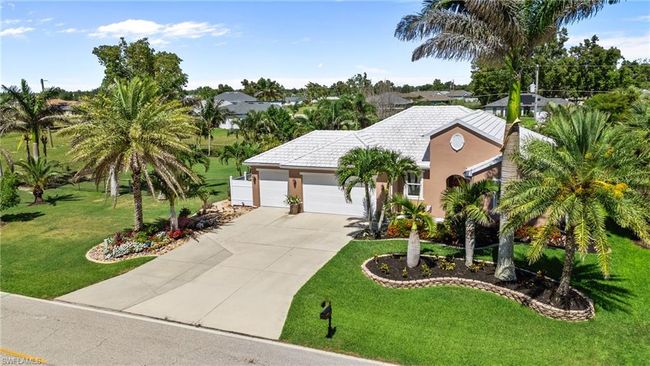 View of front of property with a garage, driveway, a front yard, stucco siding, and a tiled roof | Image 4