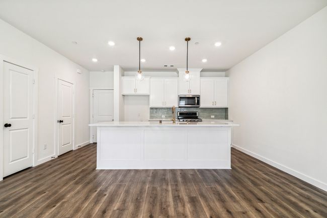 Kitchen with stainless steel microwave, baseboards, backsplash, dark wood-type flooring, and recessed lighting | Image 11