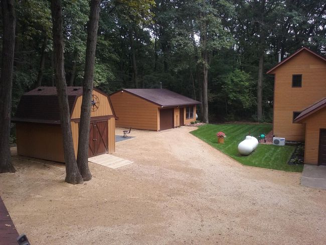 Here is a summertime view of the property, where lush foliage on the trees ensures abundant privacy. The storage shed offers generous space for all your tools & toys. The customized workshop garage is prepared for any DREAM you can envision. | Image 4