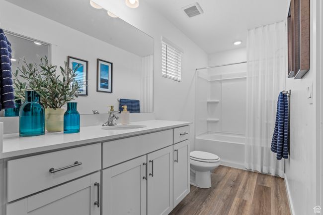 Full bathroom featuring vanity, wood finished floors, shower / tub combo, and recessed lighting | Image 16