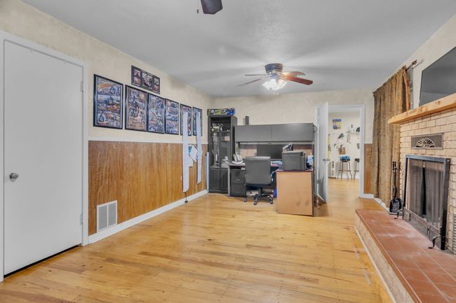 Office space with ceiling fan, wood-type flooring, and a fireplace | Image 23