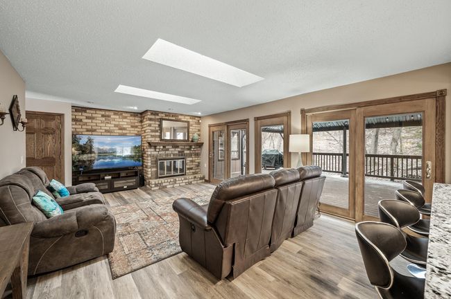 Another view of the main floor family room just off the kitchen and complete with a wood burning fireplace and skylights and access to the deck - | Image 13