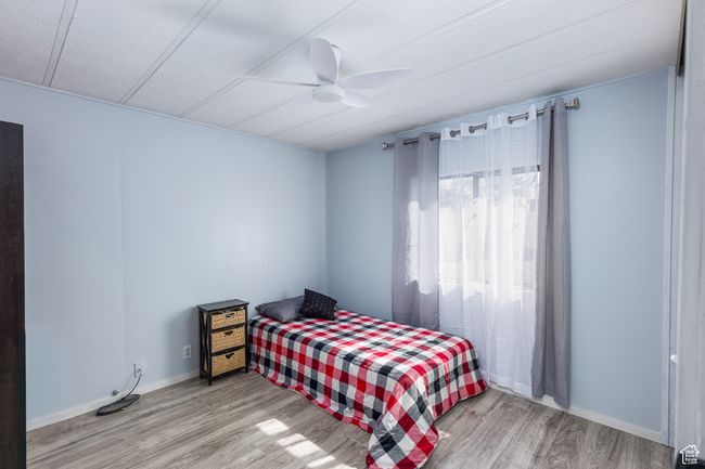 Bedroom with ceiling fan, wood finished floors, and baseboards | Image 12