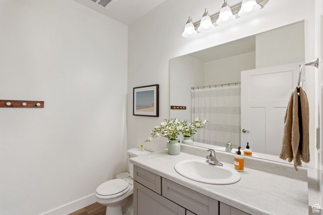 Bathroom featuring vanity, wood finished floors, and a shower with curtain | Image 10