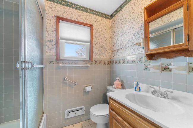 Bathroom with wallpapered walls, toilet, a wainscoted wall, tile patterned flooring, and vanity | Image 20