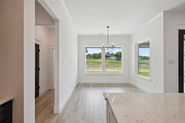 Unfurnished dining area featuring ornamental molding, a notable chandelier, and light wood-type flooring | Image 16