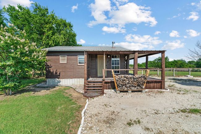 View of front of home with log veneer siding, metal roof, and a wooden deck | Image 4
