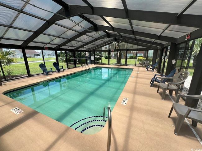 Indoor community pool featuring a lanai, a lawn, and a patio area | Image 13