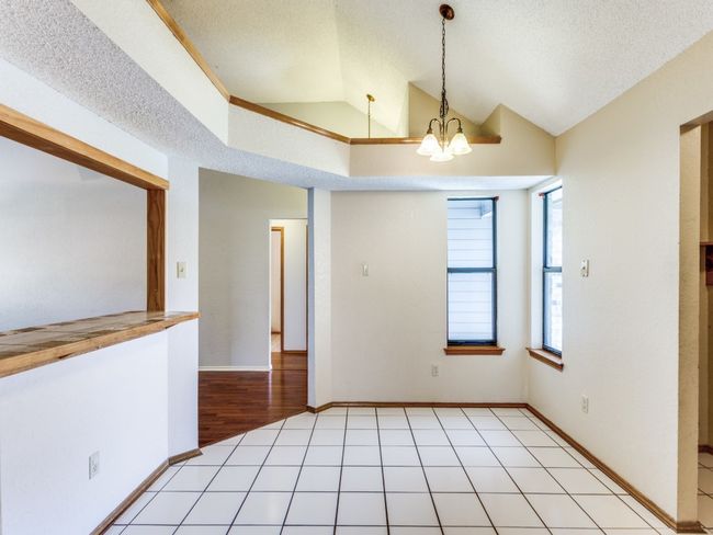 Spare room featuring lofted ceiling, a chandelier, and a textured ceiling | Image 22