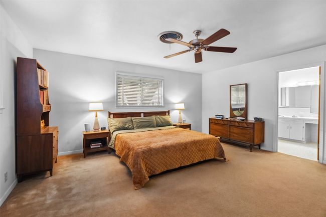 Bedroom featuring a ceiling fan, baseboards, light carpet, and ensuite bath | Image 28