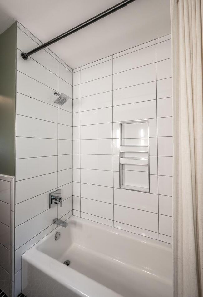 Main floor bathroom tub & shower with tile surround | Image 19