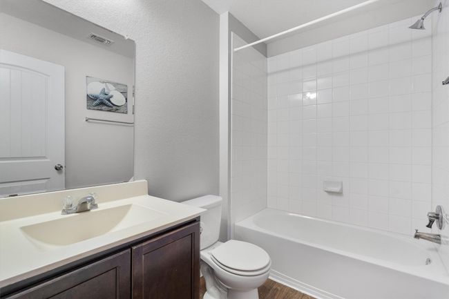 Bathroom with toilet, vanity, wood finished floors, and tub / shower combination | Image 23