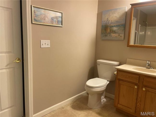 Bathroom with vanity, baseboards, toilet, tile patterned flooring, and a shower | Image 14