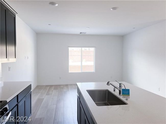 Kitchen with stainless steel range, stainless steel sink, built in microwave, light wood-type flooring, recessed lighting | Image 7