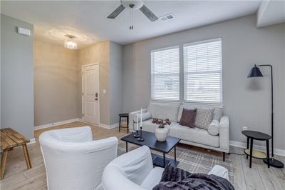 Living room with light hardwood / wood-style floors and ceiling fan | Image 1