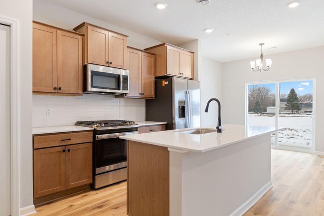 Warm wood tone colored cabinets are in this lovely Hayward plan. | Image 16