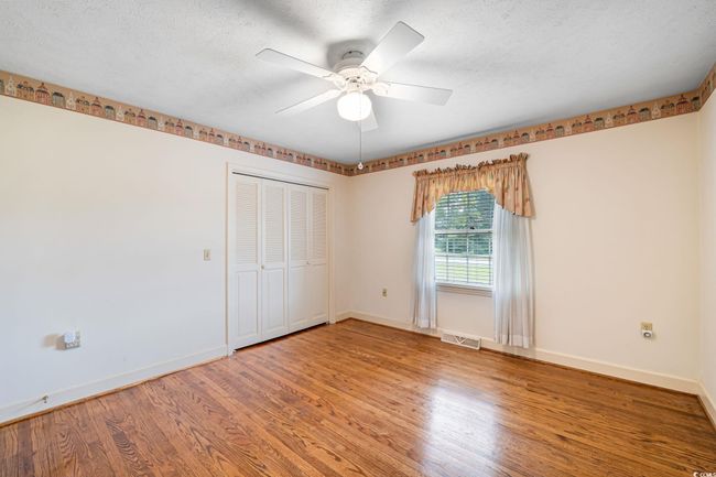 Unfurnished bedroom featuring light wood-style floors, baseboards, and a textured ceiling | Image 25