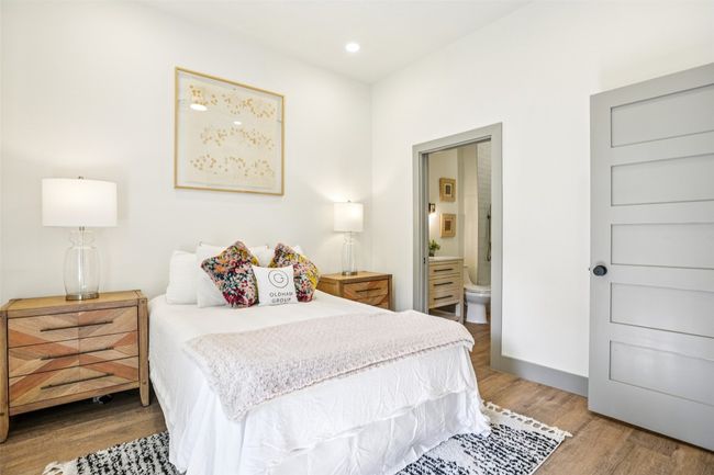 Bedroom with ensuite bathroom, wood finished floors, and recessed lighting | Image 14