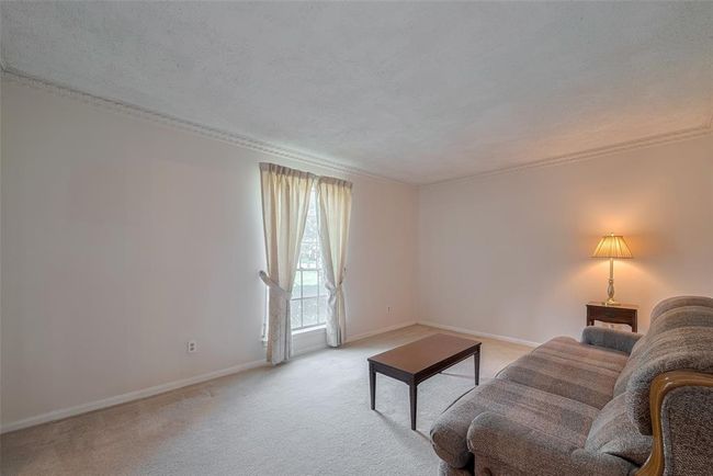 Formal living room with cozy ambiance and natural light. | Image 16