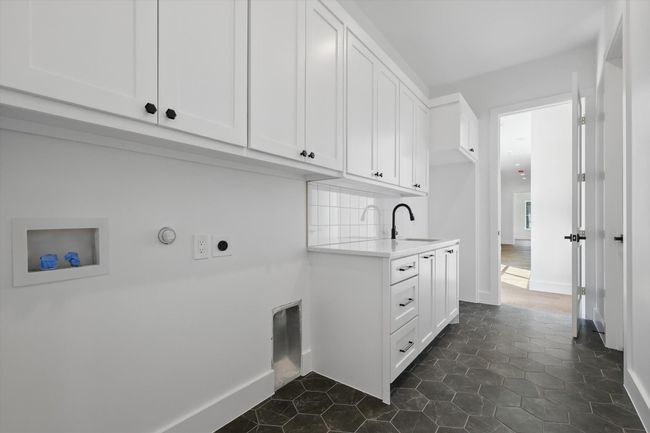 Washroom featuring hookup for a washing machine, baseboards, a sink, cabinet space, and electric dryer hookup | Image 33