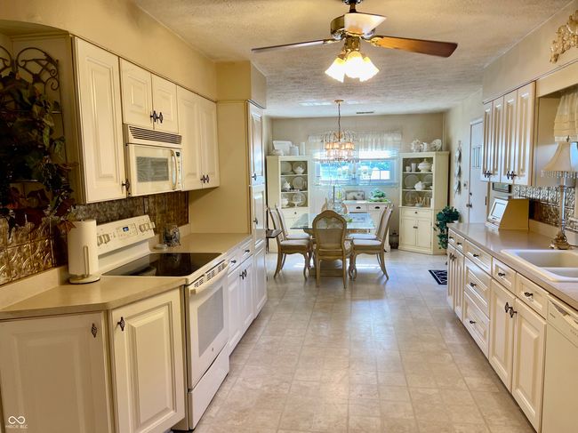 kitchen featuring white appliances with breakfast area | Image 26