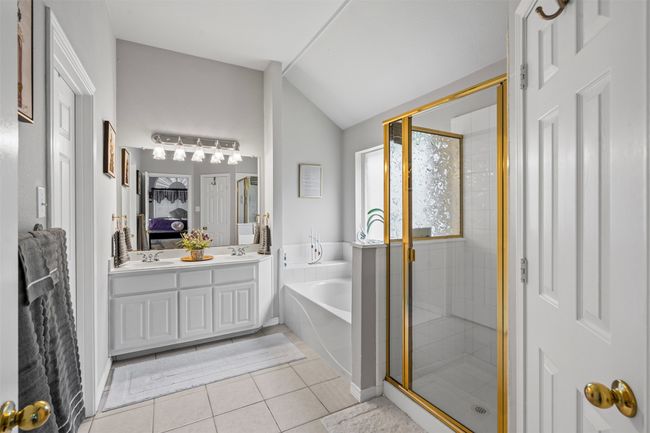 Ensuite bathroom with a garden tub, a stall shower, double vanity, vaulted ceiling, and tile patterned flooring | Image 14