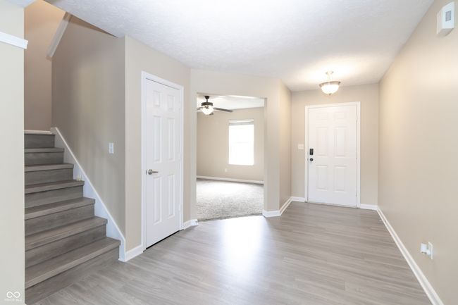 entryway with light wood finished floors, stairway, and a ceiling fan | Image 6