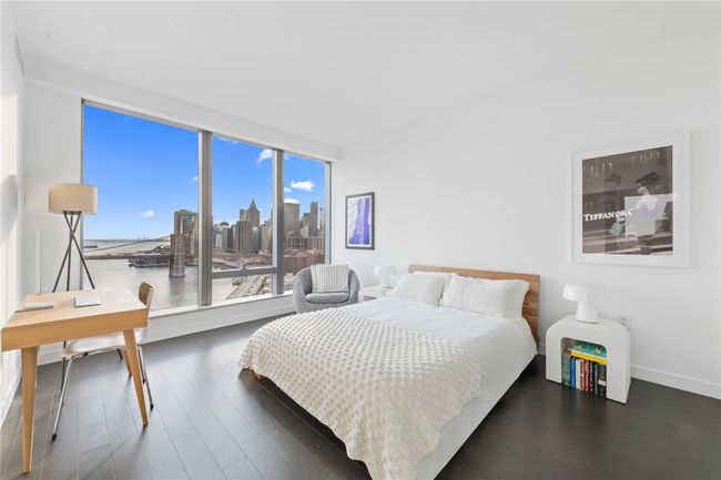 Bedroom with baseboards, wood finished floors, and a view of city | Image 7